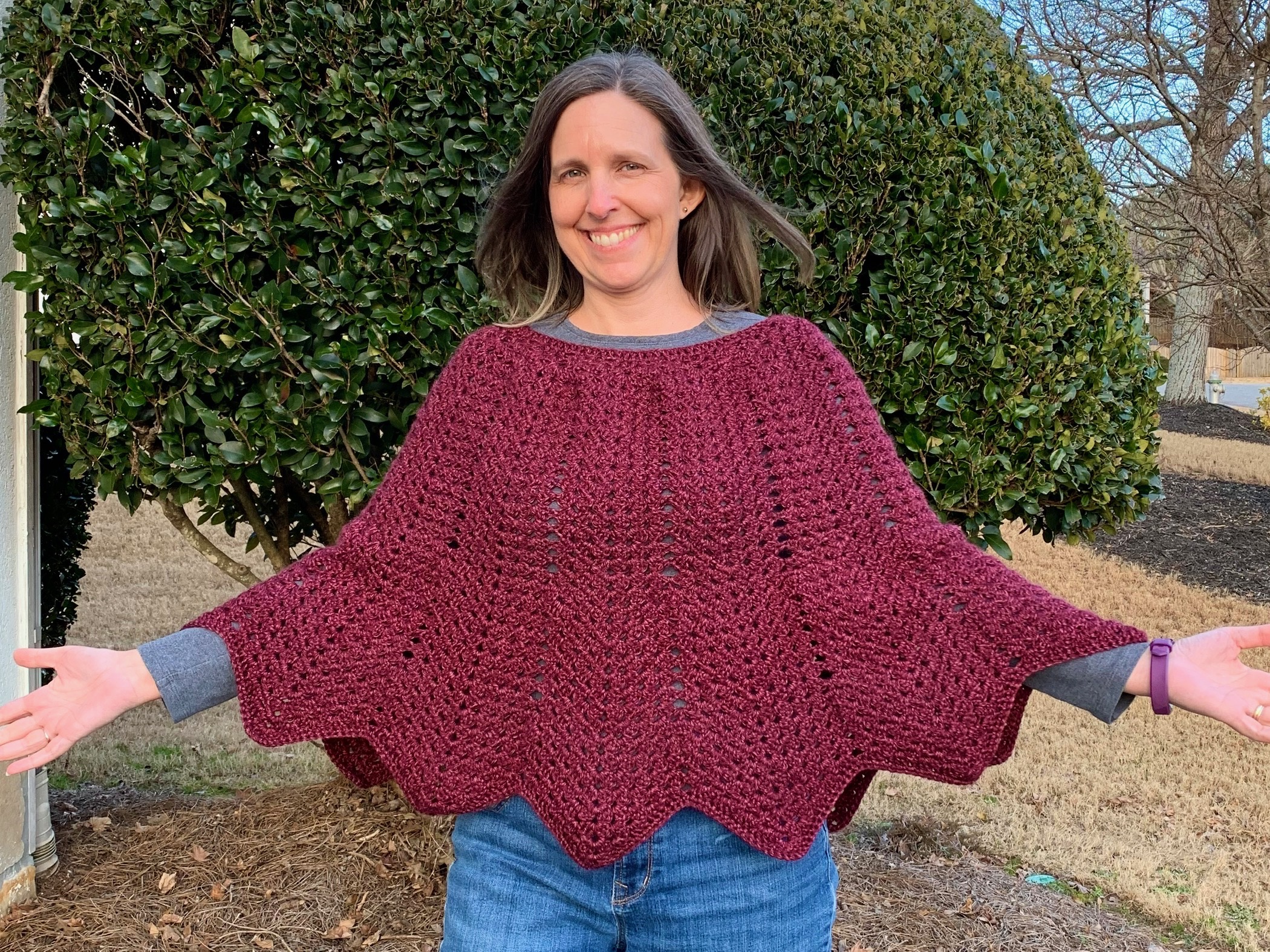 Designer wearing Granny Ripple Poncho with arms open