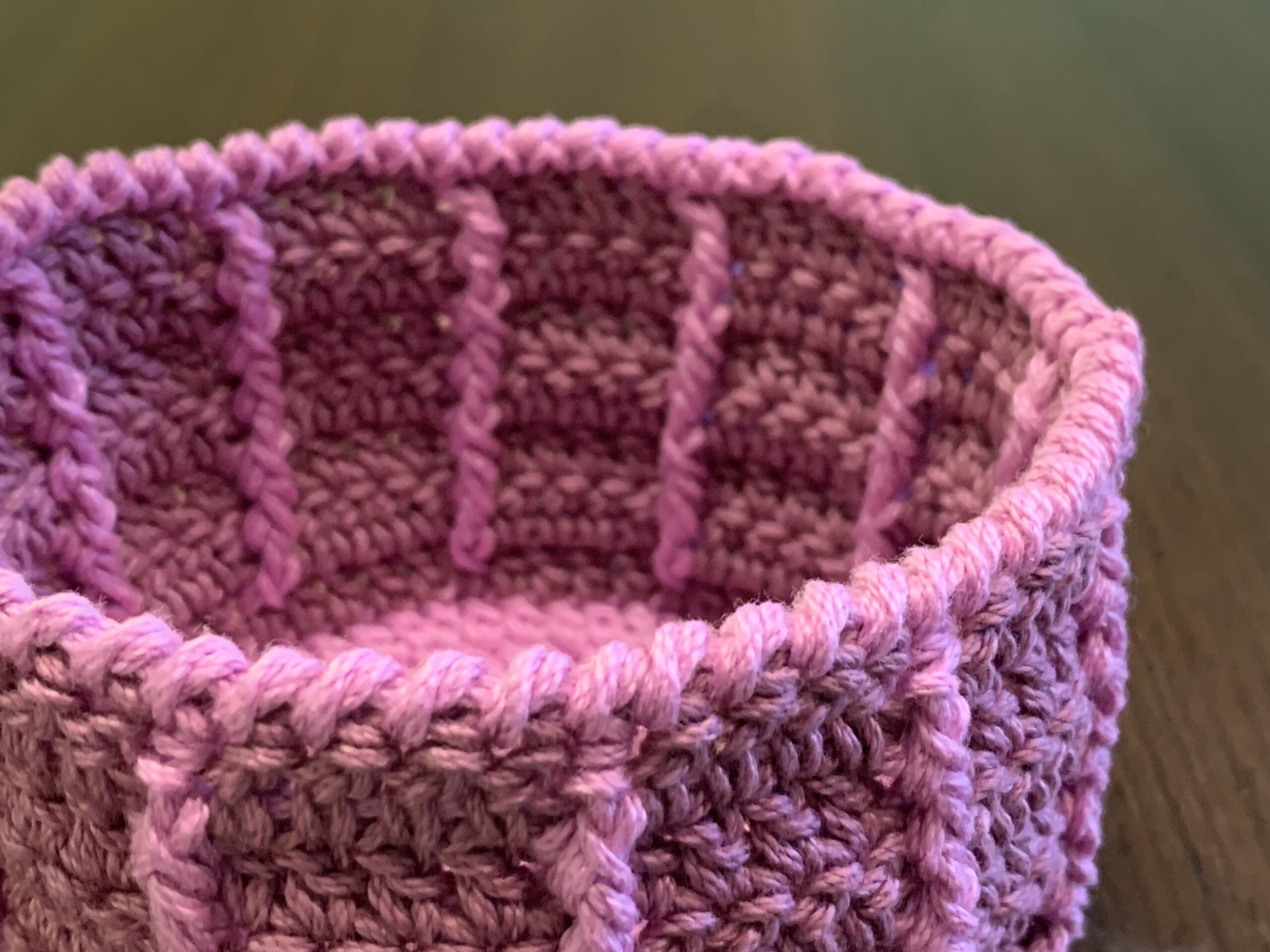 A purple basket with a crab stitch border around the rim