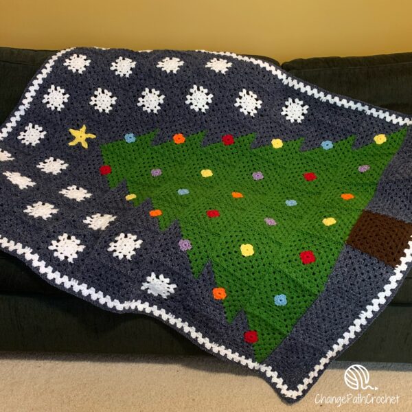 crochet christmas tree blanket laying on a couch