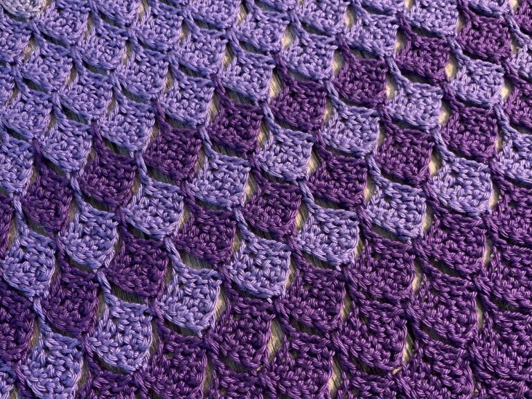 Rows of purple crochet stitches that look like feathers